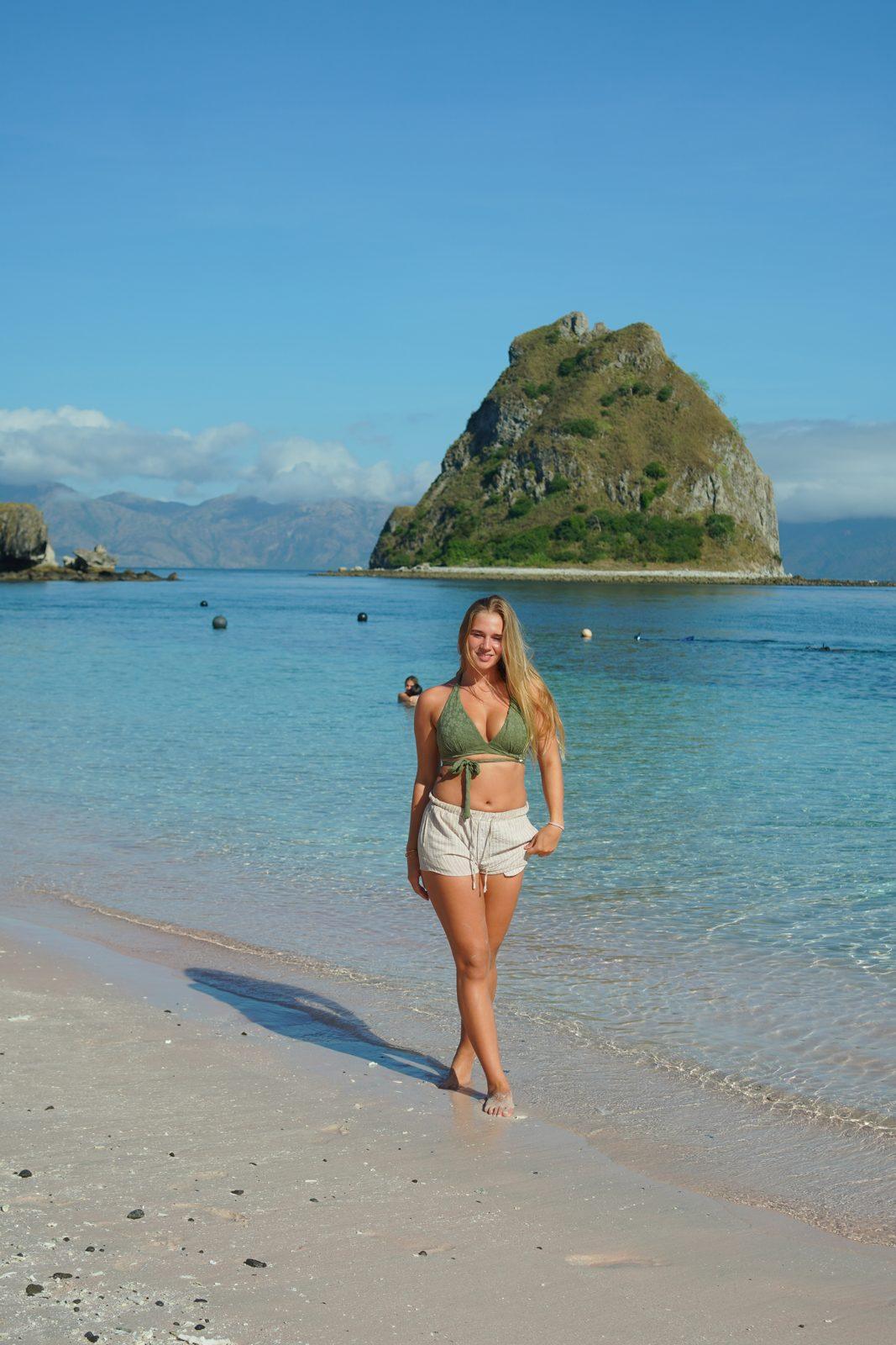 Kelor – woman standing on sand, islet behind (Real photo from a KEXI trip)