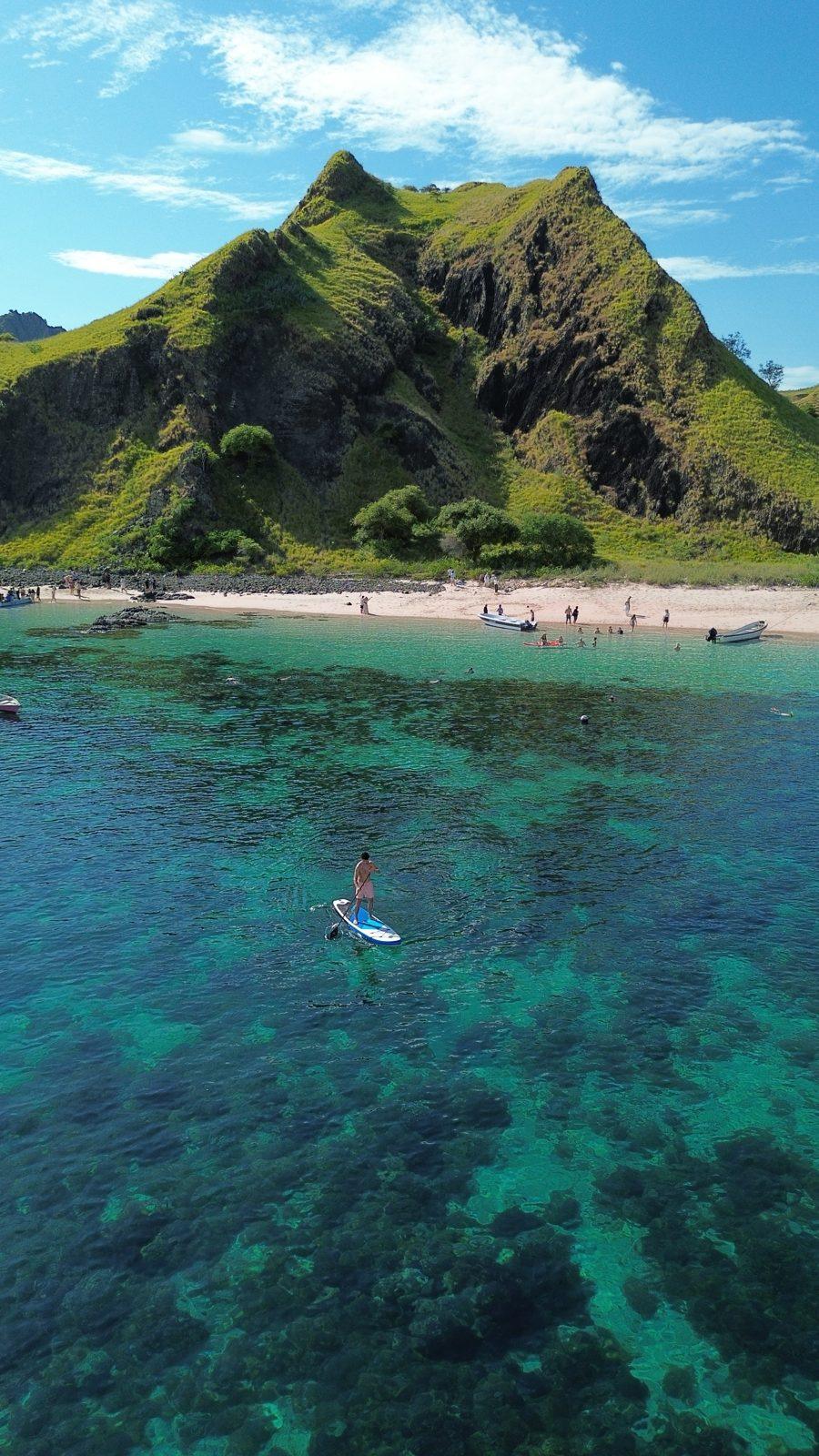 Kelor – paddleboarder off steep green hill island (Real photo from a KEXI trip)