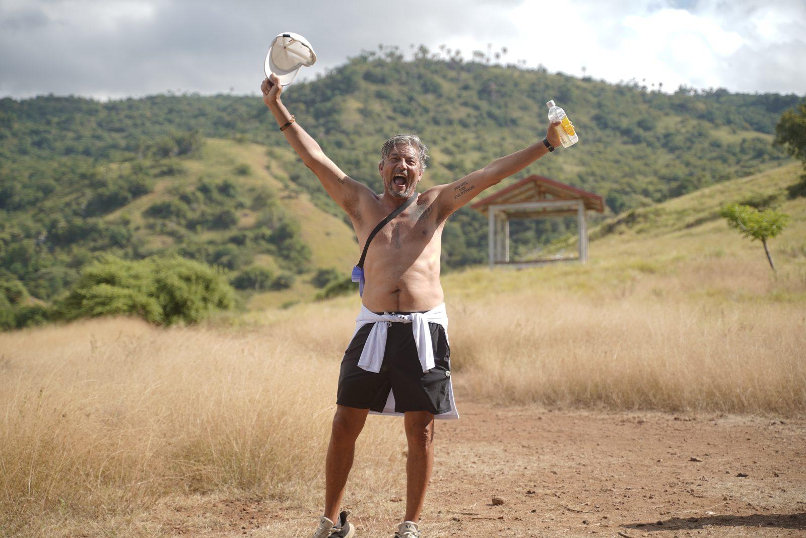 Komodo – Shirtless man cheering on savanna trail (Real photo from a KEXI trip)