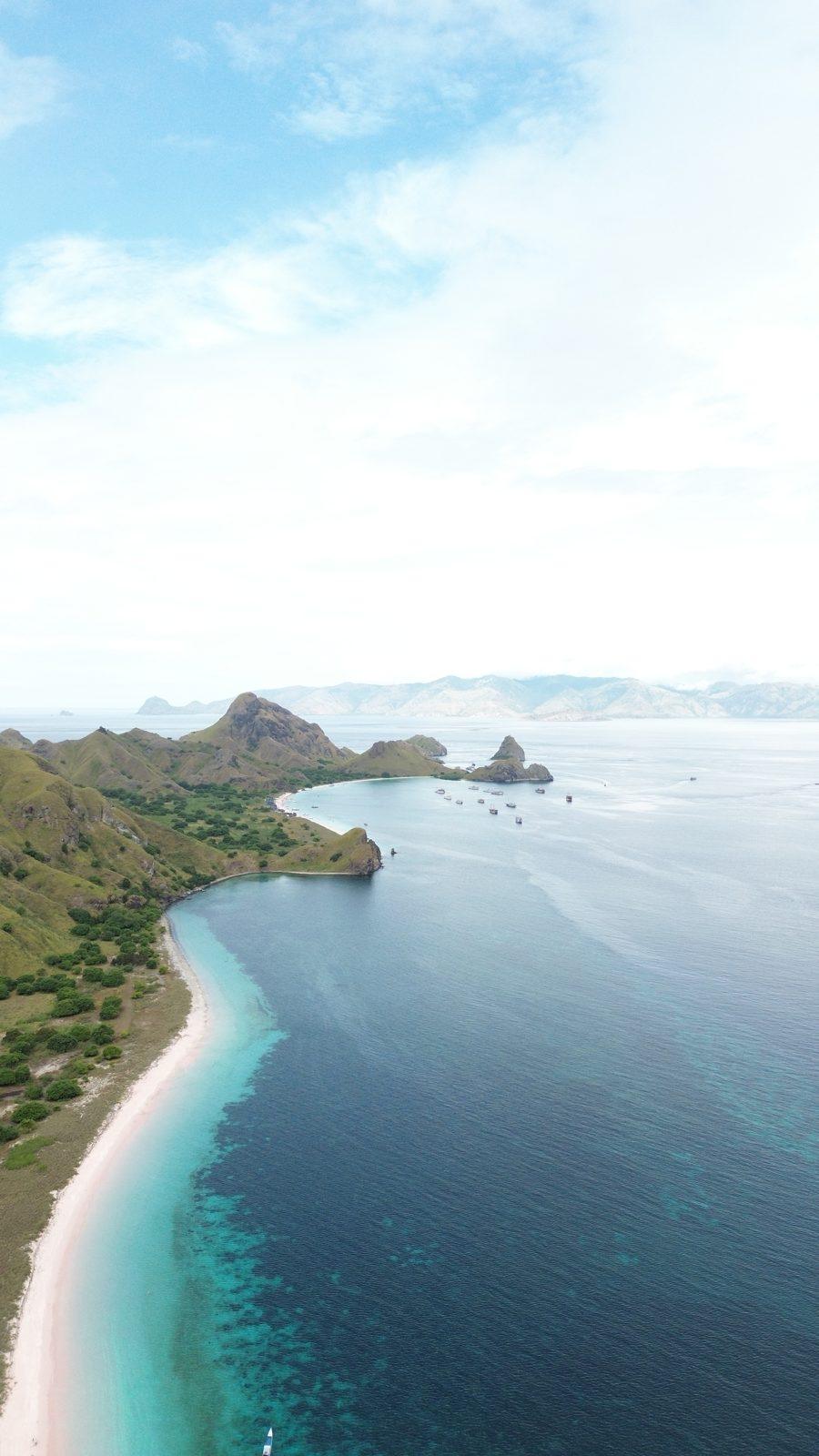 Padar – Aerial coastline, green headland, white beach (Real photo from a KEXI trip)