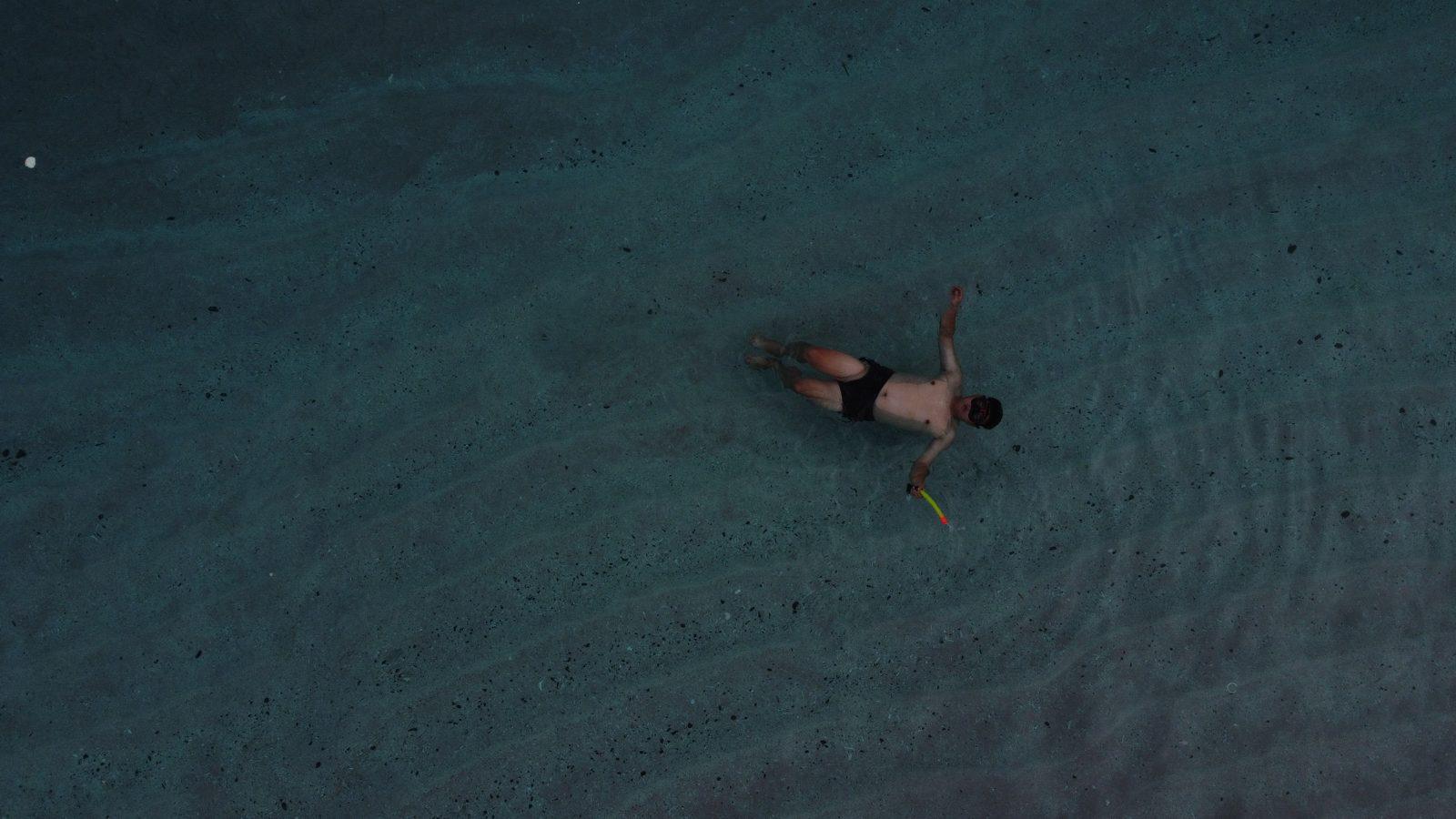 Swim Snorkel – person floating in turquoise water, drone (Real photo from a KEXI trip)